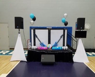 A stage with speakers and balloons on the side.